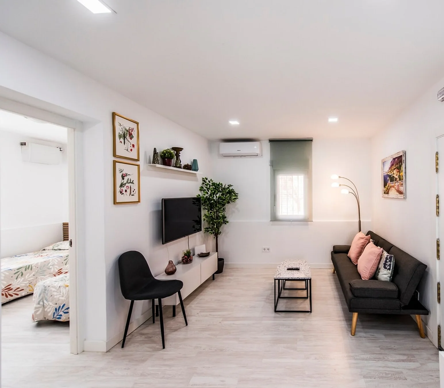 Salón de un piso gestionado en Madrid, con el dormitorio abierto al fondo