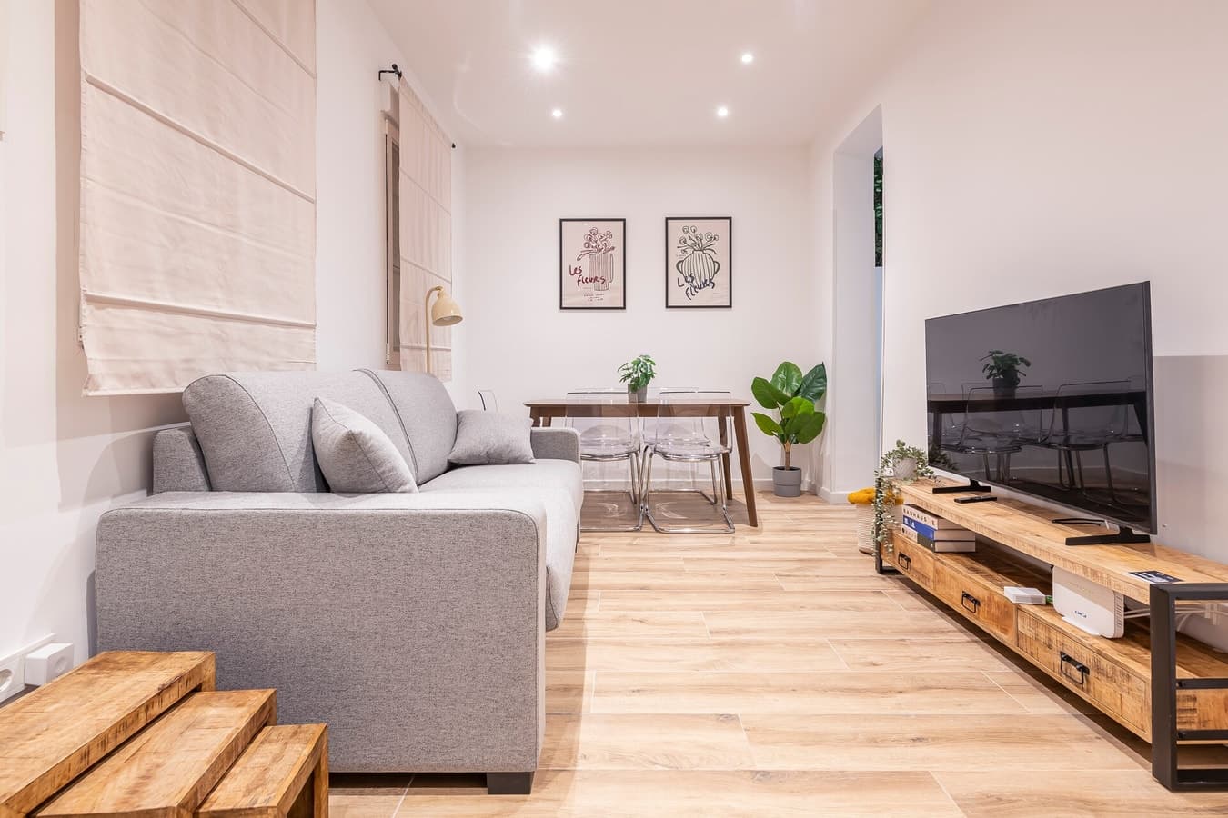 Living room of a managed property, with a grey sofa, wooden floor and framed prints
