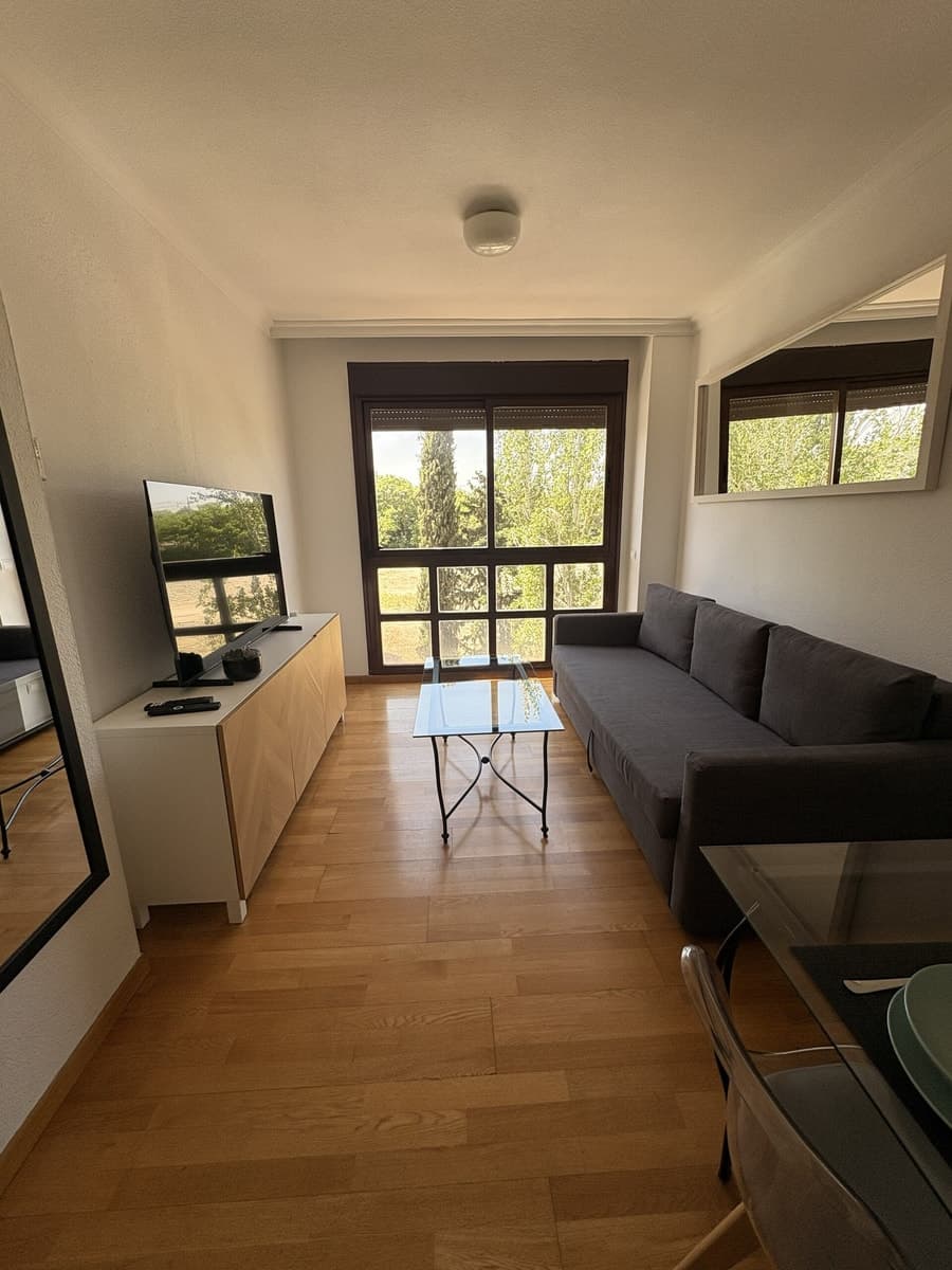 Salón de una vivienda gestionada con sofá, mesa de centro y ventana a los árboles