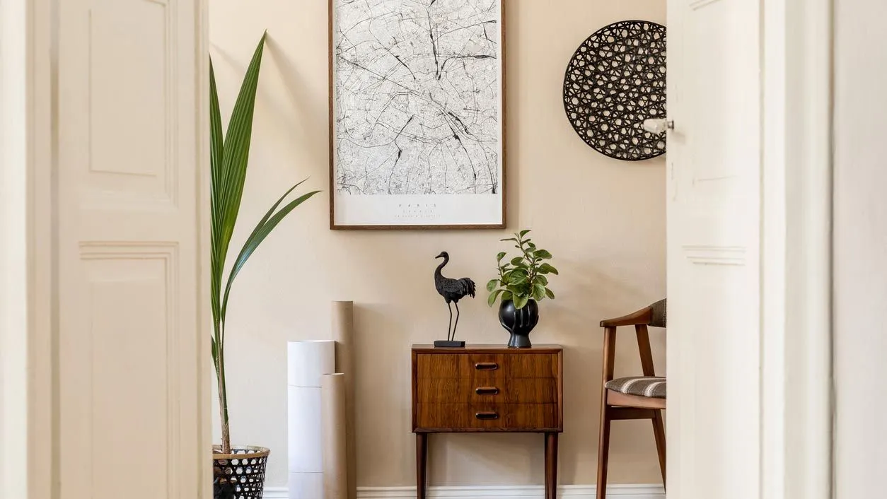 Entrance hall styled with a wooden chest of drawers, a plant and a picture after home staging